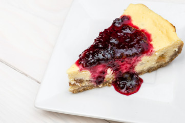 Piece of heesecake with jam on saucer. Top view.
