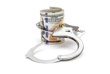 Opened handcuffs with rolled money on white.