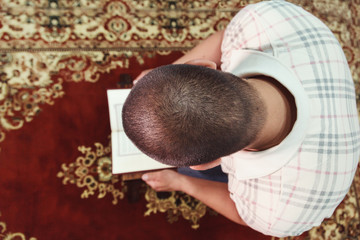 Muslim man reading Islamic holy book quran