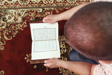 Muslim man reading Islamic holy book quran