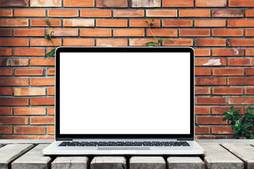 Laptop computer isolated white screen for mockup design on brick wall background