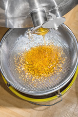 Honig ist am fließen aus dem Schleuder Gerät durch den Sieb