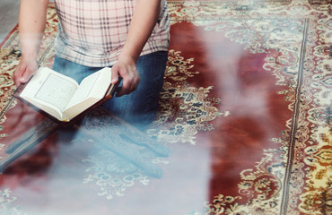 Muslim man reading Islamic holy book quran