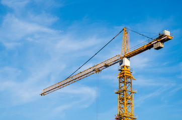 Orange crane against blue clear sky, copy space