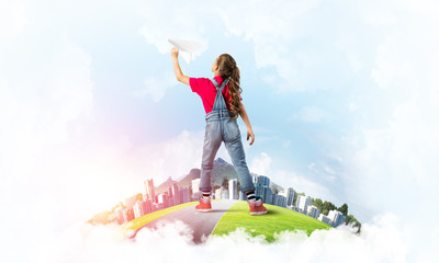 Concept of careless happy childhood with girl dreaming about future