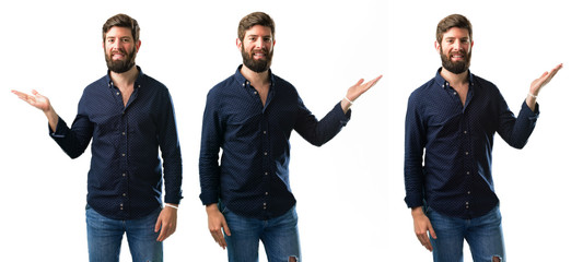 Young man with beard holding something in his empty hand isolated over white background