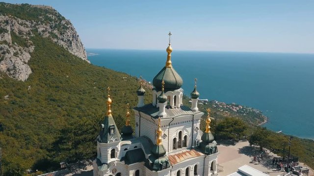 Orthodox church on a steep cliff. Sea and mountains on a background. Aerial view of Foros Church on a mountain over the sea.