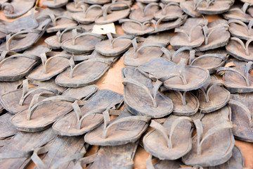 A sale of flip-flops made out of tyres in a marketplace.