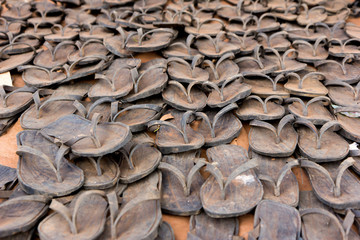 A sale of flip-flops made out of tyres in a marketplace.