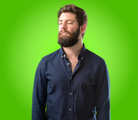 Obraz premium Young hipster man with big beard confident and happy with a big natural smile looking side over green background