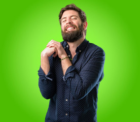 Young hipster man with big beard confident and happy with a big natural smile laughing over green background