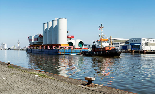 Bremerhaven, Transport von Windenergieanlagen durch den Hafen, Schlepper mit Schute im Fischereihafen