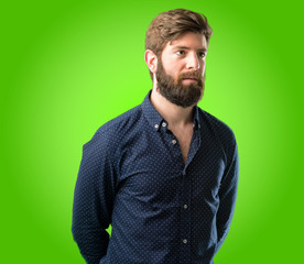 Young hipster man with big beard confident and happy with a big natural smile looking at camera over green background
