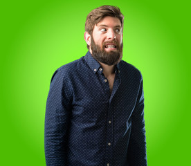 Obraz premium Young hipster man with big beard confident and happy with a big natural smile laughing over green background