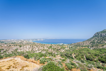 Beautiful sunny coast view to the greek mediterranean blue sea with crystal clear water and pure sandy beach empty place with some mountains rocks surrounded, Kefalos, Kos Island, Dodecanese, Greece