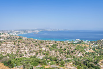 Beautiful sunny coast view to the greek mediterranean blue sea with crystal clear water and pure sandy beach empty place with some mountains rocks surrounded, Kefalos, Kos Island, Dodecanese, Greece