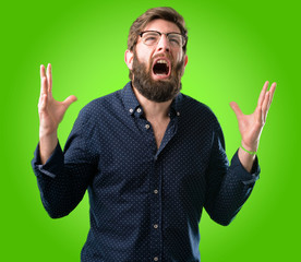 Young hipster man with big beard terrified and nervous expressing anxiety and panic gesture, overwhelmed over green background