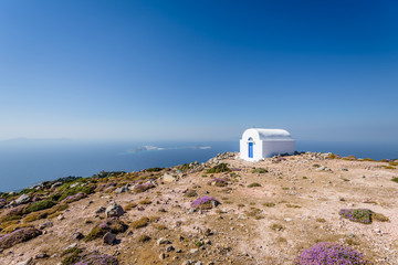 Holy greek white blue chruch chapel of agios Ilias shining above a greek island over the...