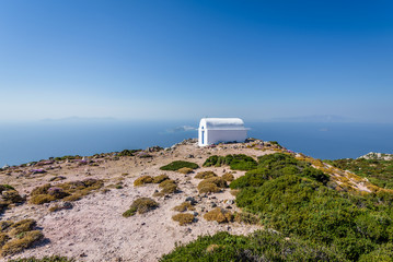 Holy greek white blue chruch chapel of agios Ilias shining above a greek island over the...