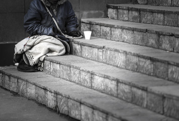 Homeless poor woman begging for money outdoors