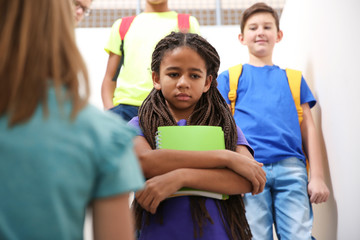 Sad African American teenage girl indoors. Bullying in school