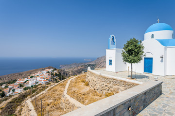 Fototapeta na wymiar Holy greek white blue chruch chapel of agios theologos sant john shining above the village Nikia over the greek sea on the edge of a volcano on the island of Nisyros, Kos, Dodecanese, Greece