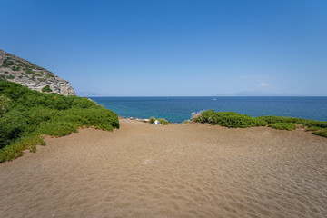 Sunny beautiful summer coast view to the greek blue sea white pure dark brown sand perfect for...