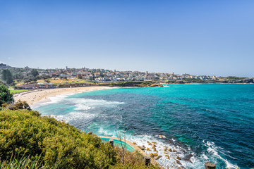 Fototapeta premium Sunny beautiful summer coast view to Sydney beach and blue Tasman Sea wild wave water and sandy white beaches perfect for surfing swimming hiking, Coogee to Bondi Walk, NSW/ Australia - 10 11 2017