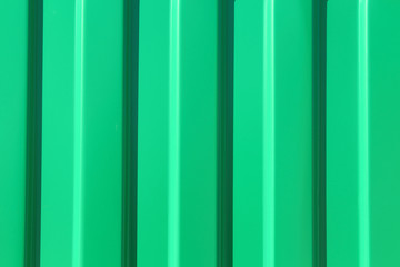 Green metal sheet of corrugated sheet. Close-up. Background. Texture.