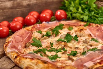 Homemade fresh delicious gourmet pizza whit shrimps, porcini mushrooms, speck, garlic and fresh parsley,Tasty italian pizza isolated on wooden table,Close up with selective focus
