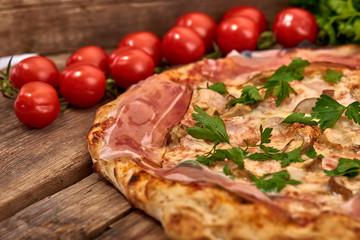 Homemade fresh delicious gourmet pizza whit shrimps, porcini mushrooms, speck, garlic and fresh parsley,Tasty italian pizza isolated on wooden table,Close up with selective focus