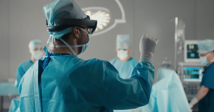 MED Team of surgeons using augmented reality holographic hololens headset while operating in modern operation theater. 4K UHD 60 FPS SLO MO