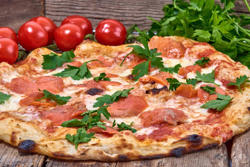 Homemade fresh delicious gourmet pizza whit salmon, garlic and fresh parsley,Tasty italian pizza isolated on wooden table,Close up with selective focus