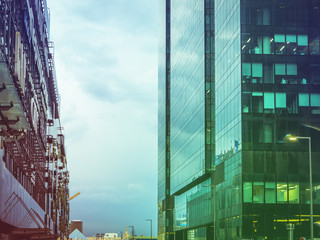 Fototapeta premium tall skyscrappers close up against cloudy stormy sky