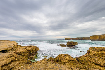 Cloudy sunny summer coast view to a beautiful sandy beach bay and rocky erosion sand limestone...