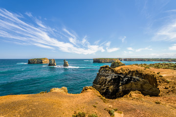 Bright sunny summer coast view to a beautiful sandy beach bay and rocky erosion sand limestone...