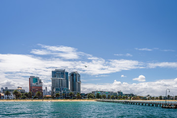 Obraz premium Port Melbourne, Victoria, Australia: Beautiful sunny coast view to australian blue sea and beach port harbour with cruise ship Sprit of Tasmania at shore and white gull jetty to beach bay