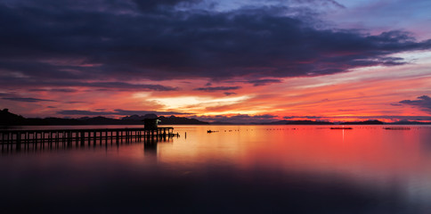 Fototapeta na wymiar old small jetty in to the sea in Long exposure image of dramatic sunset or sunrise,sky and clouds over tropical sea scenery landscape.