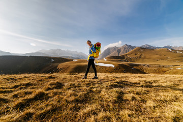 a young girl travels through the Caucasus mountains with a backpack and tent, leads an active lifestyle