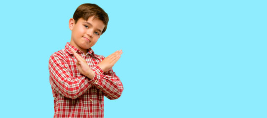 Handsome toddler child with green eyes annoyed with bad attitude making stop sign crossing hands,...