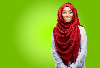 Young arab woman wearing hijab confident and happy with a big natural smile looking side