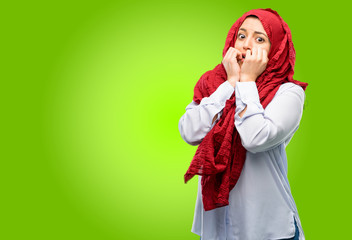 Young arab woman wearing hijab terrified and nervous expressing anxiety and panic gesture, overwhelmed