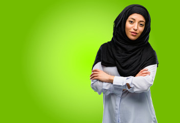 Young arab woman wearing hijab with crossed arms confident and happy with a big natural smile laughing