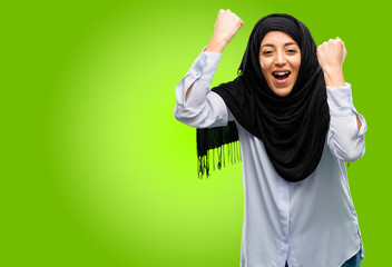Young arab woman wearing hijab happy and excited celebrating victory expressing big success, power, energy and positive emotions. Celebrates new job joyful