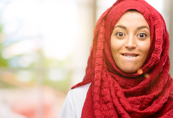 Young arab woman wearing hijab confident and happy with a big natural smile looking side