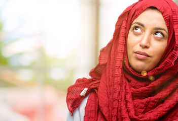 Young arab woman wearing hijab making funny face fooling