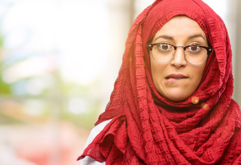 Young arab woman wearing hijab nervous and scared biting lips looking camera with impatient expression, pensive