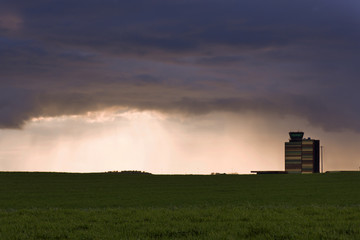 Fototapeta premium Panorámica del aeropuerto de Lleida-Alguaire, campo de colza en primer término, cielo nuboso, lloviendo, tormenta.