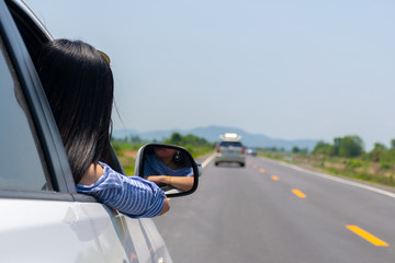 Naklejka premium Woman drive a car on the road with a mountain