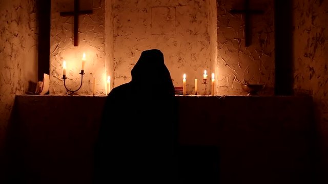 The monk walks the dark room to the altar
